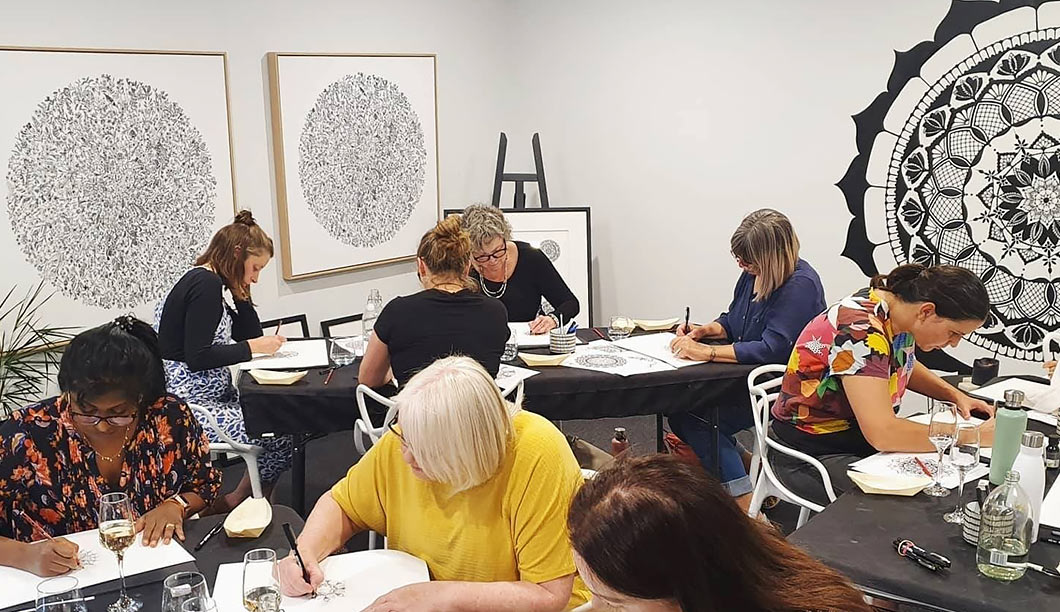 A small group gathered around a table for a guided mandala-drawing circle